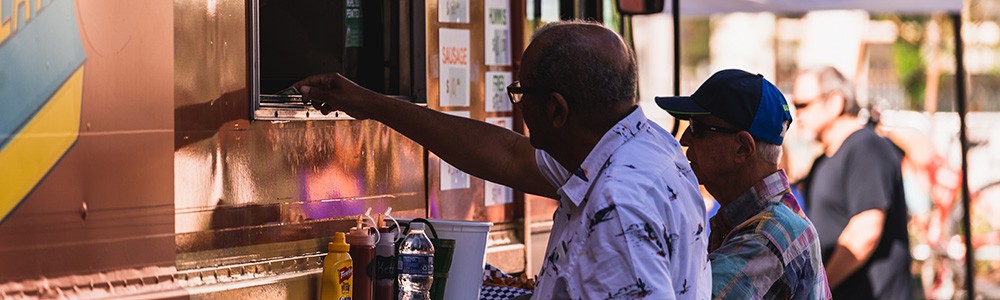 two people buying food from a food truck