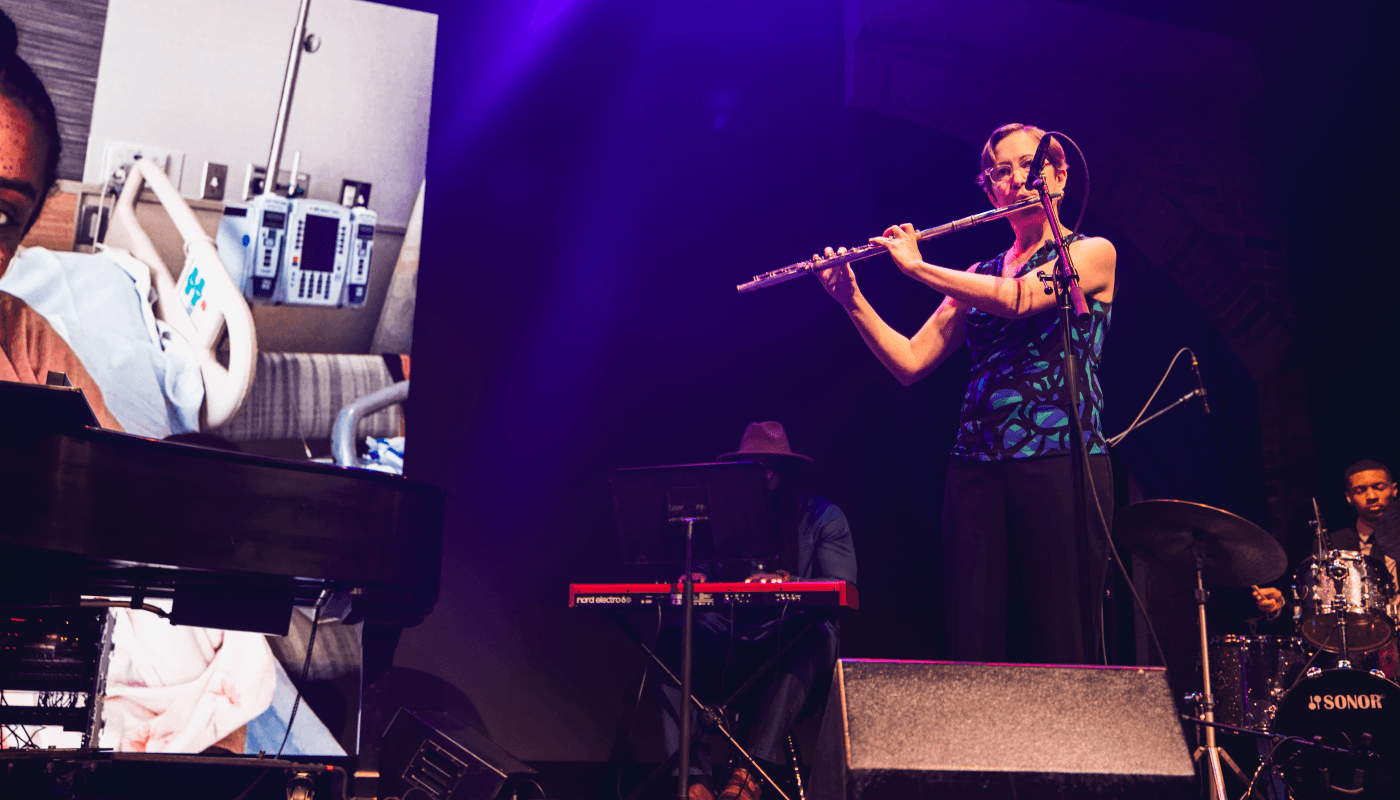 Lynn Speakman, a female musician, plays the flute on stage.