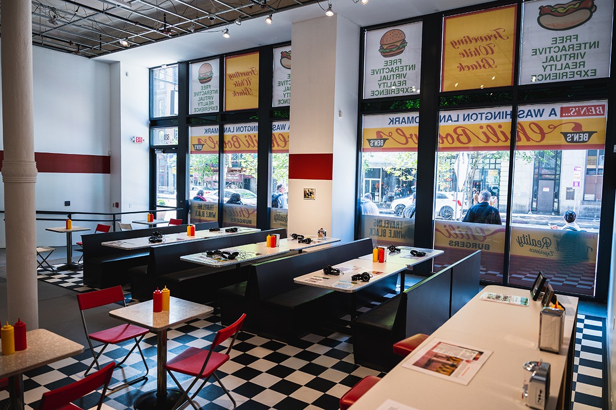a gallery space set up to look like a vintage diner, with booths and tables