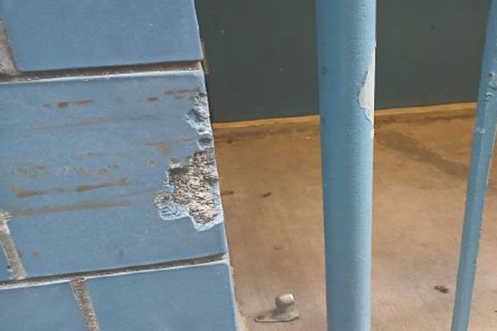 A close up of the blue O'Reilly facade with some scratches before repairs are made.