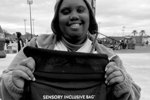 a person holding up a black, drawstring Kulture City sensory bag