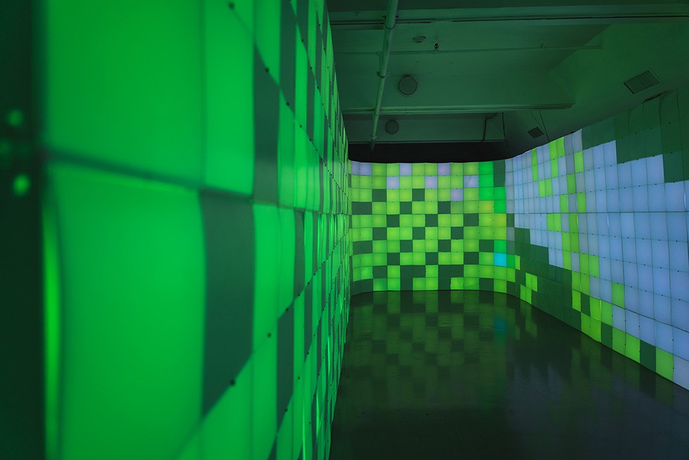 a chamber surrounded by walls made of green light up blocks