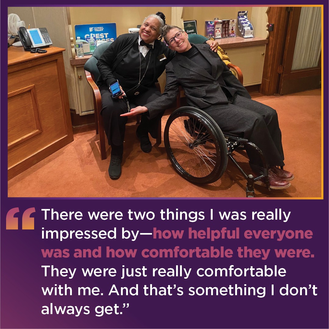 Tess, a woman in her wheelchair, poses with front of house staff member in the Guest Services Lobby.