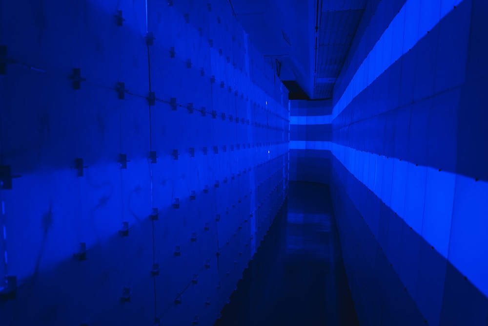 a corridor made of two walls of blue light up blocks
