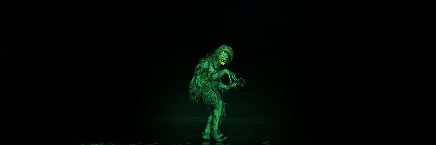 The Grinch sneaks across a stage