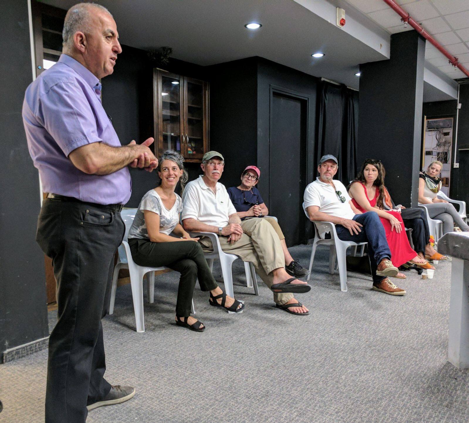 Sayid Abu Shaqra conducts a discussion with a room full of people