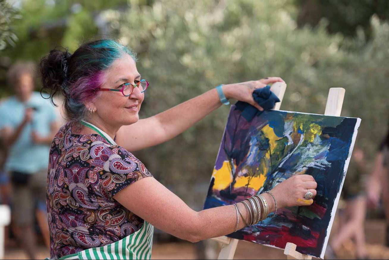 Tal Gaash paints at her easel
