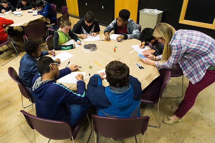 a table of male students participate in arts workshop