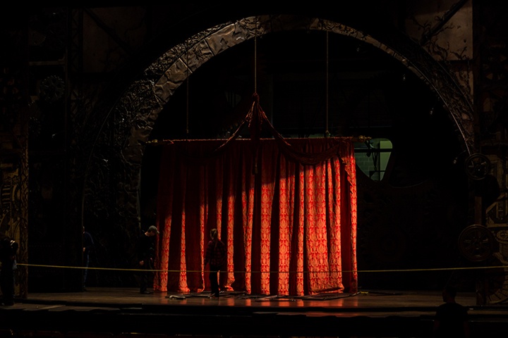 stagehands set up a curtain as part of the wicked set