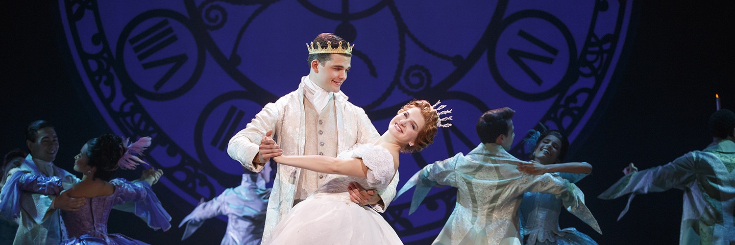 Actors playing Cinderella and Prince Topher dance center stage