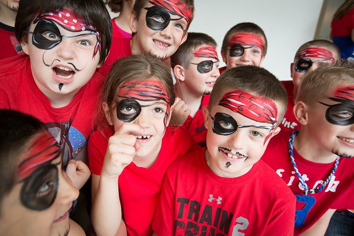 a group of kids with pirate face paint pose for the camera
