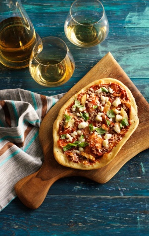 a pizza served on a wooden pizza paddle