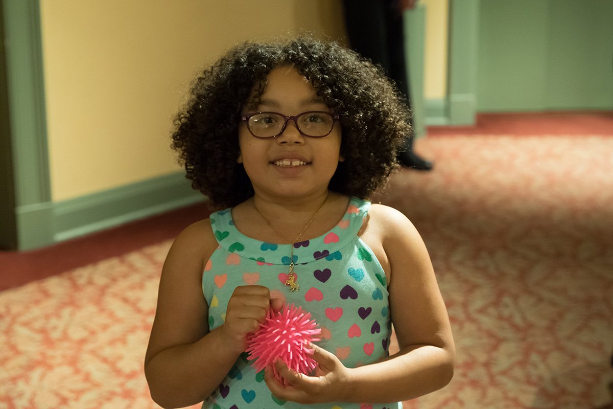 little girl in glasses holding fidget at sensory-friendly show