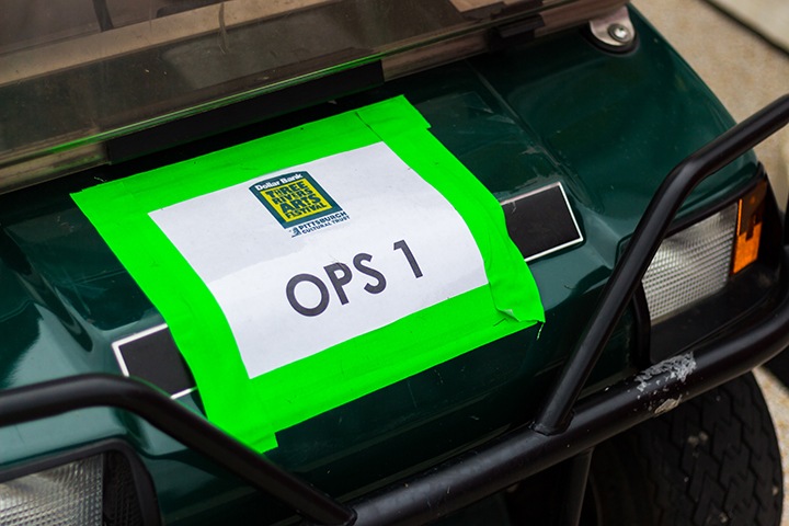 the front of a golf cart with a sign reading 'ops 1' and the arts festival logo