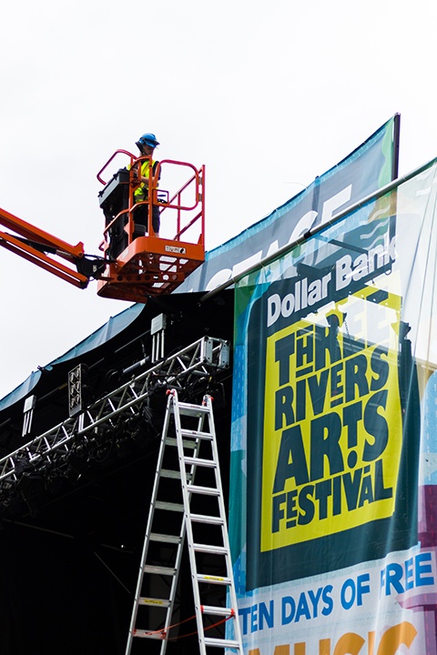 a worker on a lift assembles the dollar bank main stage