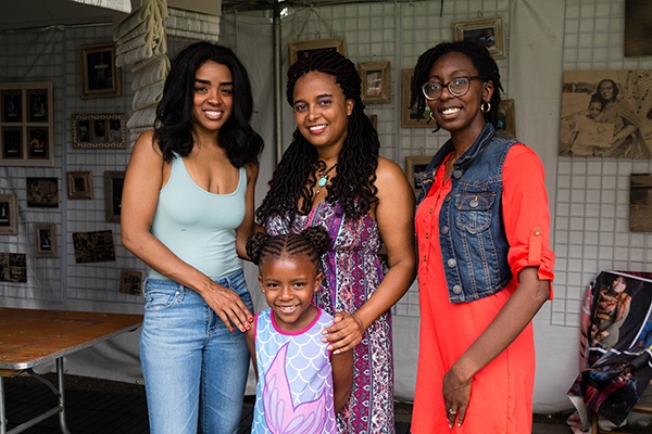 four women in front of photo display