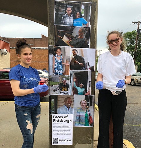 two students wheatpasting at the Afro American Music Institute