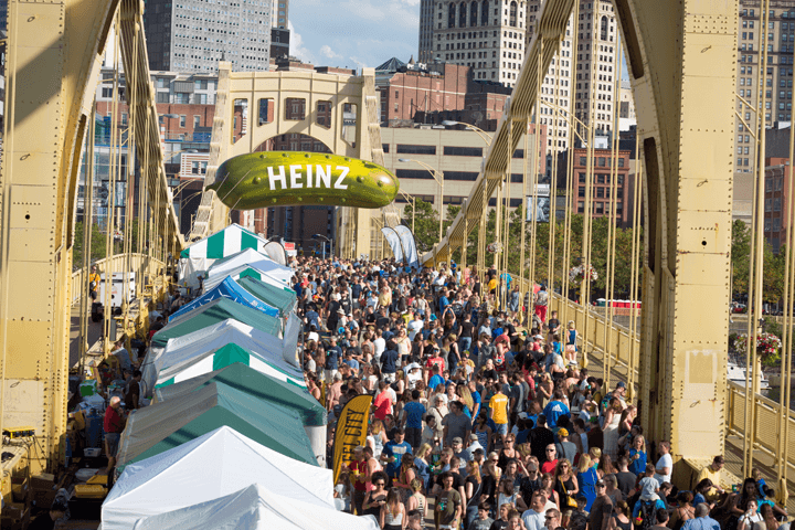 a large crowd fills the Celemente bridge with Pickleburgh's signature floating pickle above