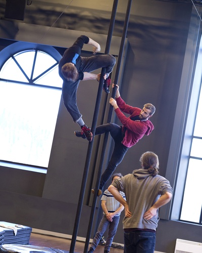 two circus performers climbing a chinese pole