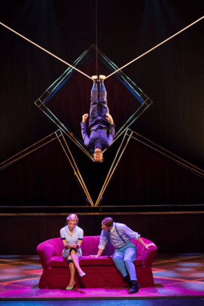 circus performing hanging by his heels above two unsuspecting hotel guests