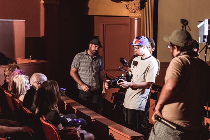 members of the production crew setting up a shot in the byham theater auditorium
