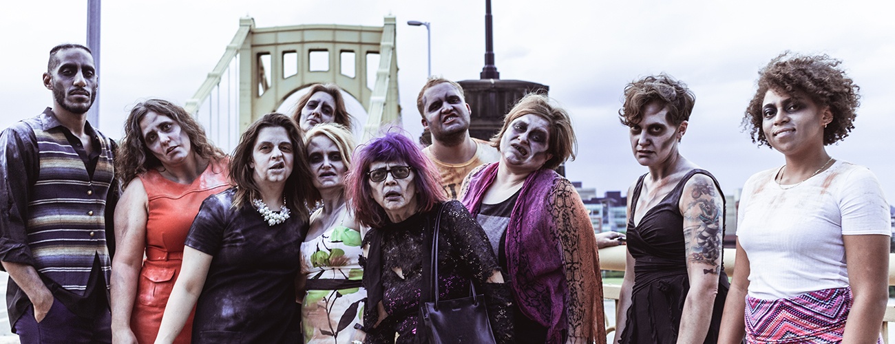 our motley crew of zombies posing by one of pittsburgh's golden bridges