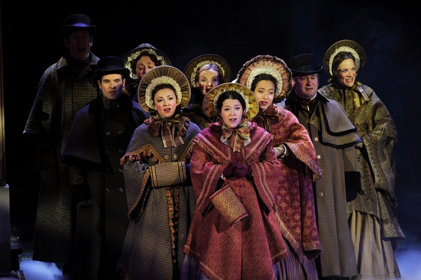 a group of huddled victorian-styled actors on stage
