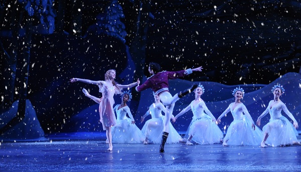 two ballet dancers dancing on stage in snow