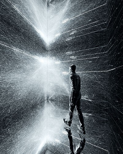 man facing light projects in dark room
