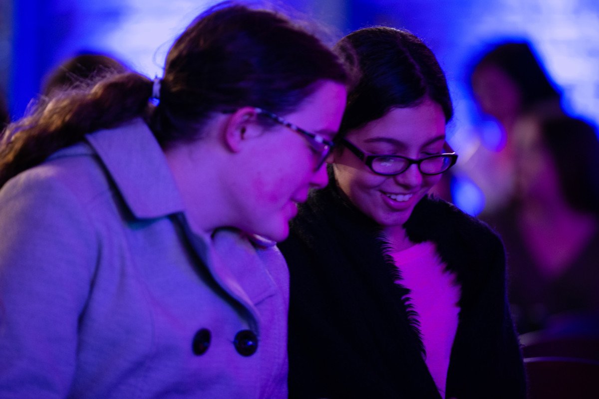 two teens smile while reading at Bookish in the 'Burgh