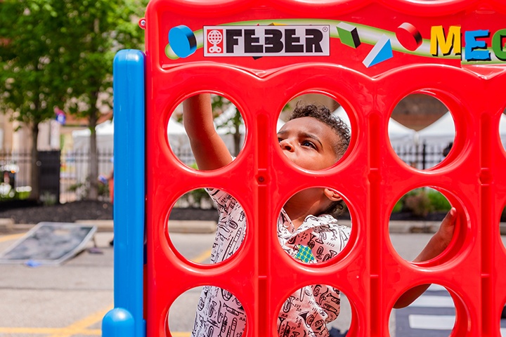 a young child plays a giant game of connect four