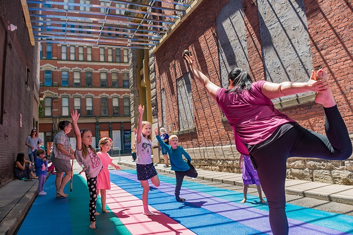 a group of children are led in yoga by an instructor