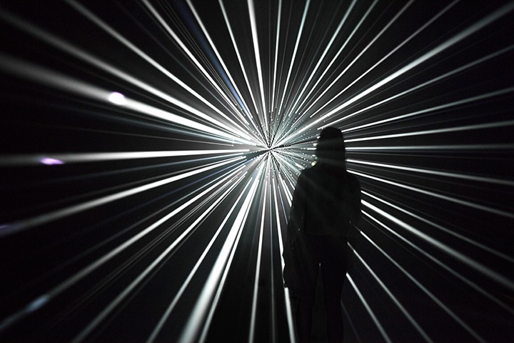 a photo of a person standing in front of one of Mythologies' light installations