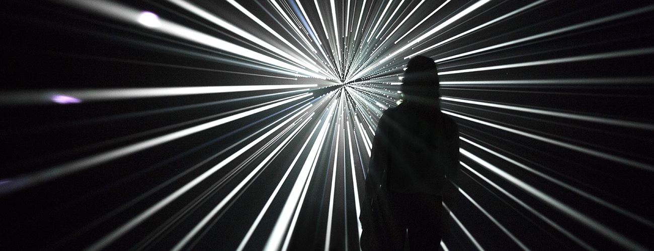 a photo of a person standing in front of one of Mythologies' light installations
