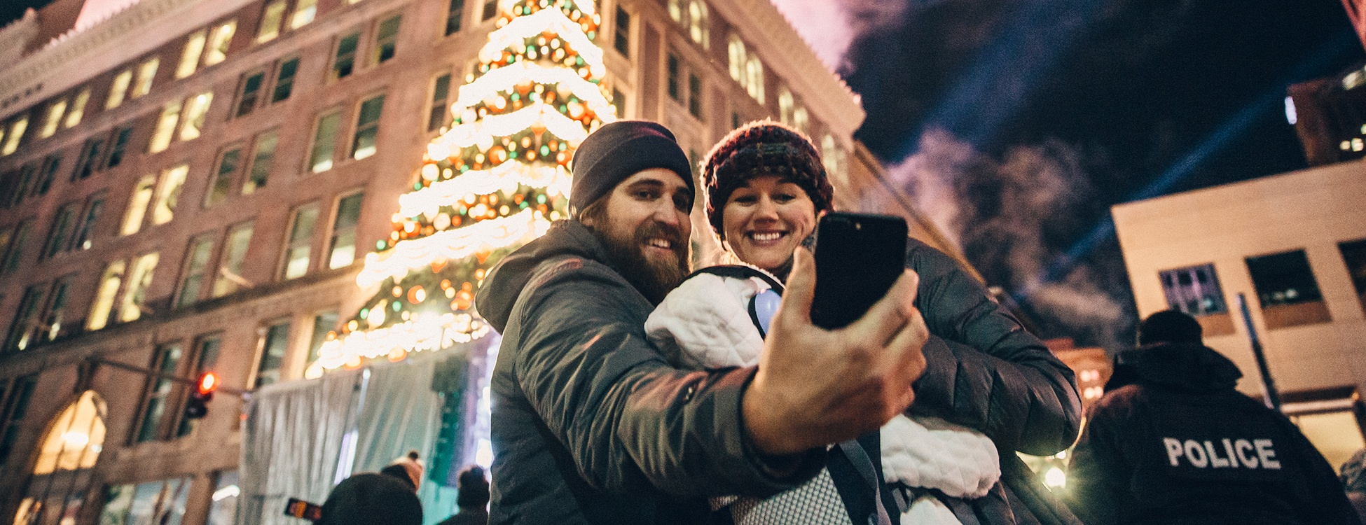 Couple taking selfie in front of tree downtown