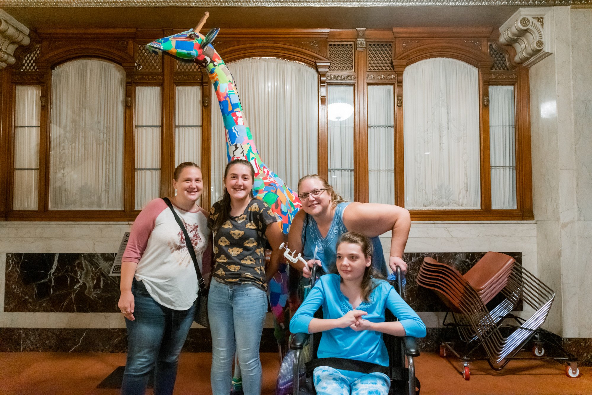 Family posing for a photo with giraffe made out of flip-flops, from Ocean Sole Africa