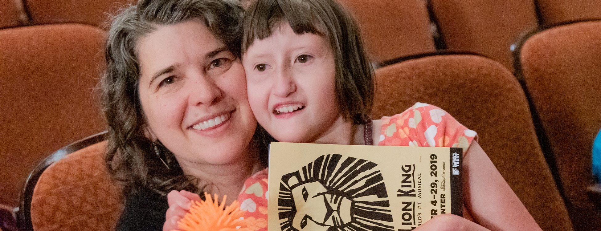 Header photo of girl and mother embracing at the Lion King Sensory Friendly performance