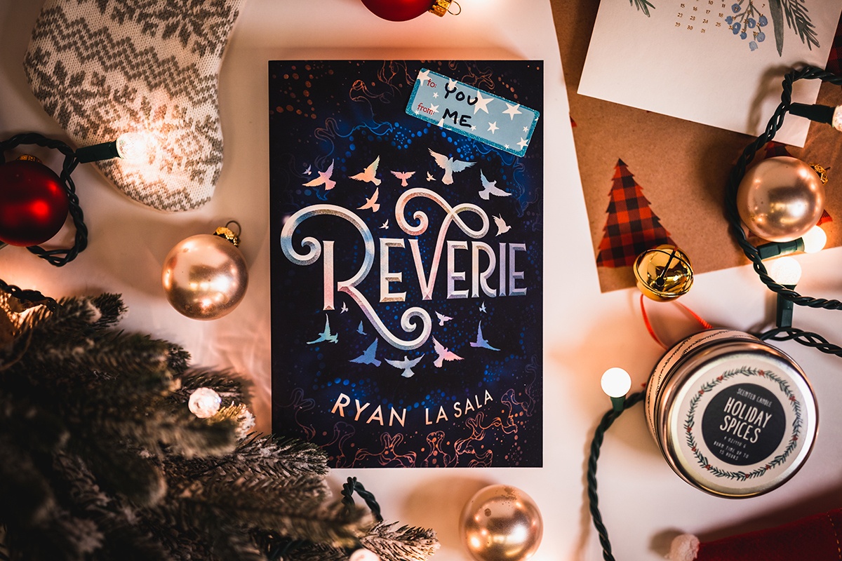 a photo of Ryan La Sala's book 'reverie' surrounded by holiday decorations