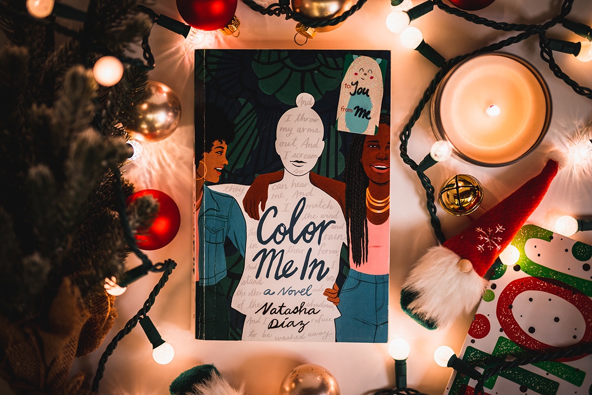 a photo of Natasha Díaz's book 'color me in' surrounded by holiday decorations