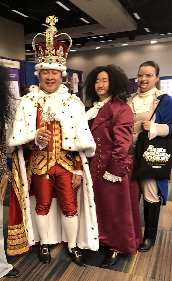 three people dressed in cosplay, one being king george from hamilton