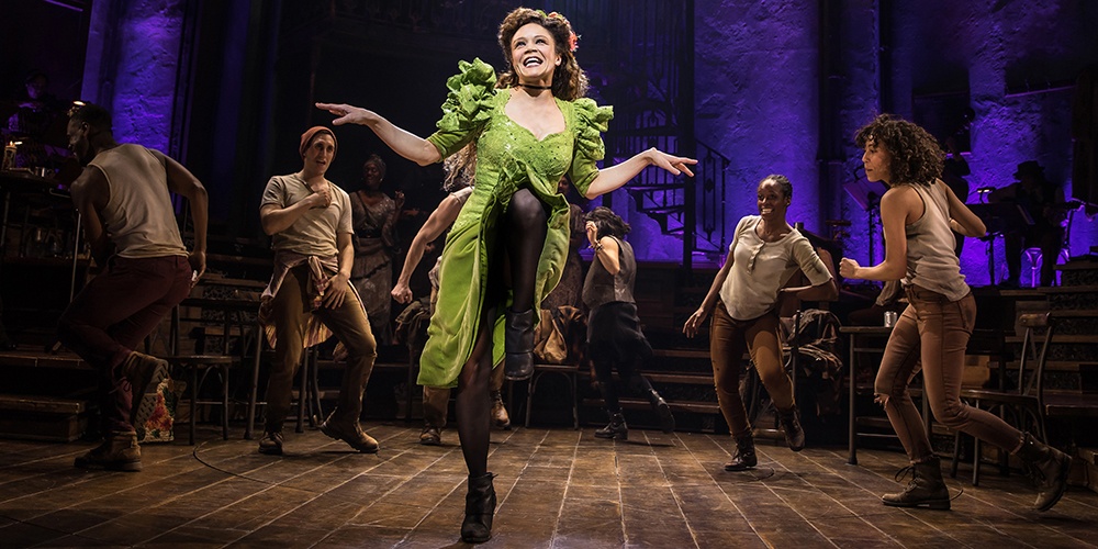 Amber Gray, center, singing and dancing. Other cast members dance behind him.