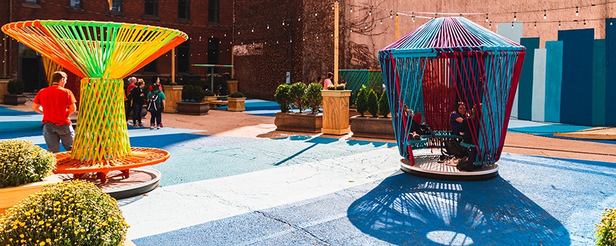 the trust oasis with colorful interactive public art spinning seats