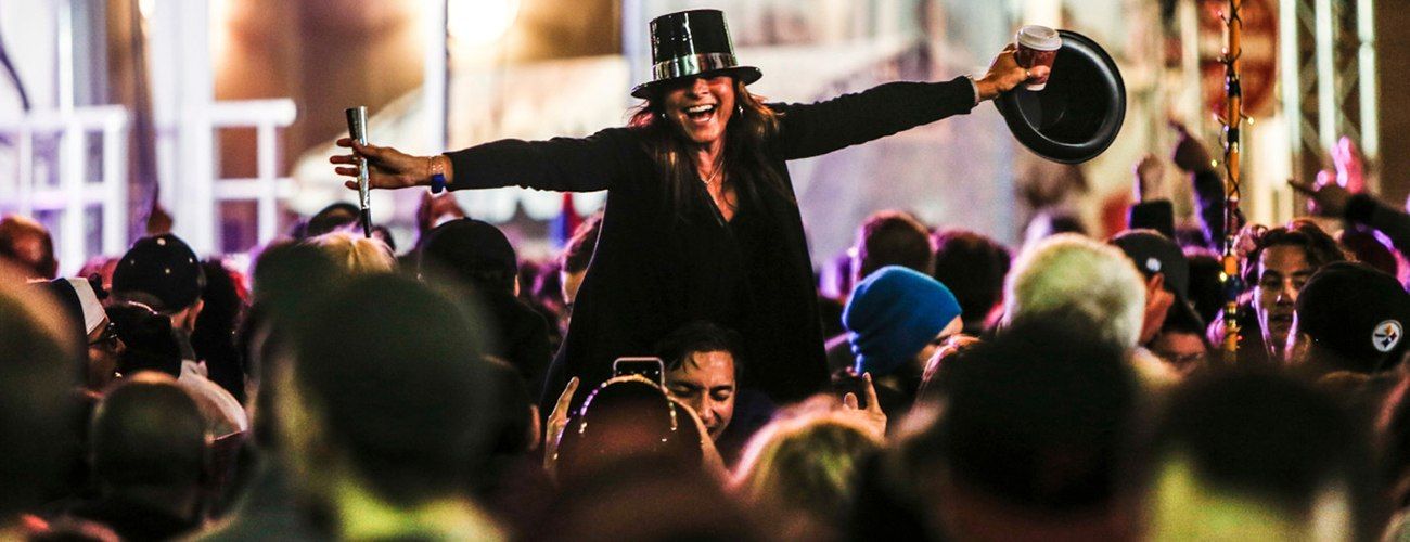 woman lifted above the crowds at New Year's Eve celebration, Highmark First Night Pittsburgh
