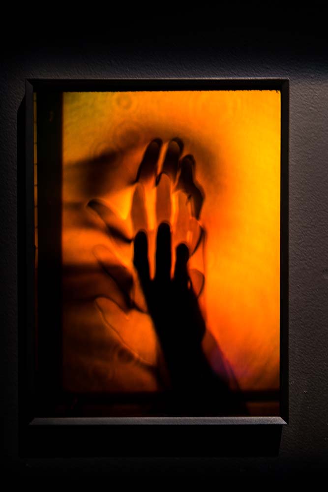 A detailed view of a yellow and orange hologram of a blurred, moving hand