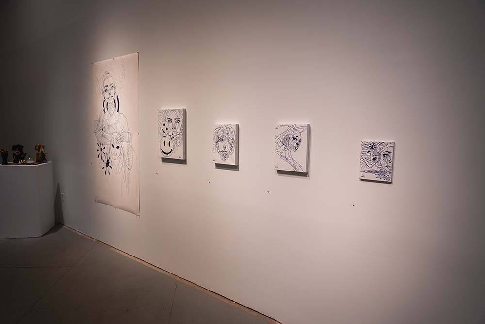  Five black and white drawn portraits hung on a wall