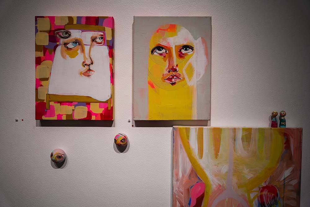 A close up of two abstract paintings of faces