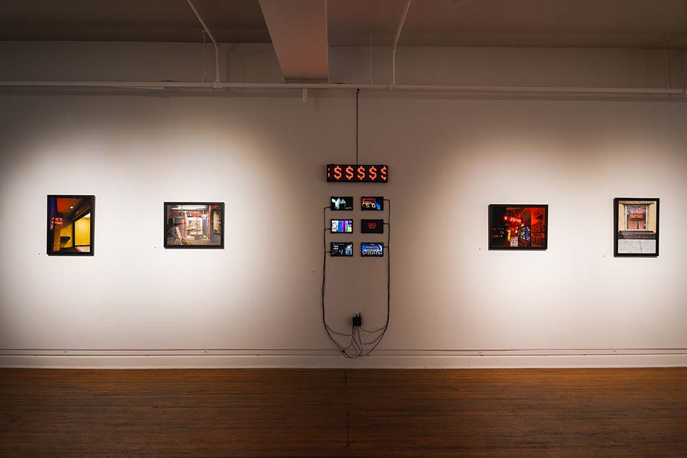 A gallery wall hung with four photos and six tablets