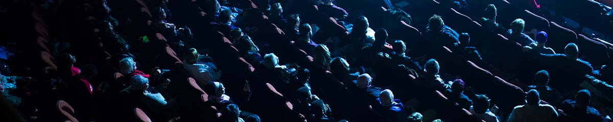 A birds eye view of rows and rows of full seats during a performance