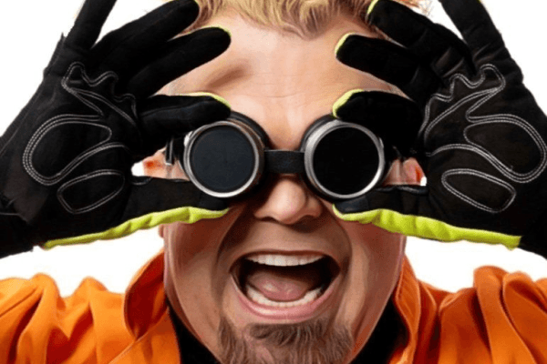 man with black goggles holds up black gloved hands around his eyes