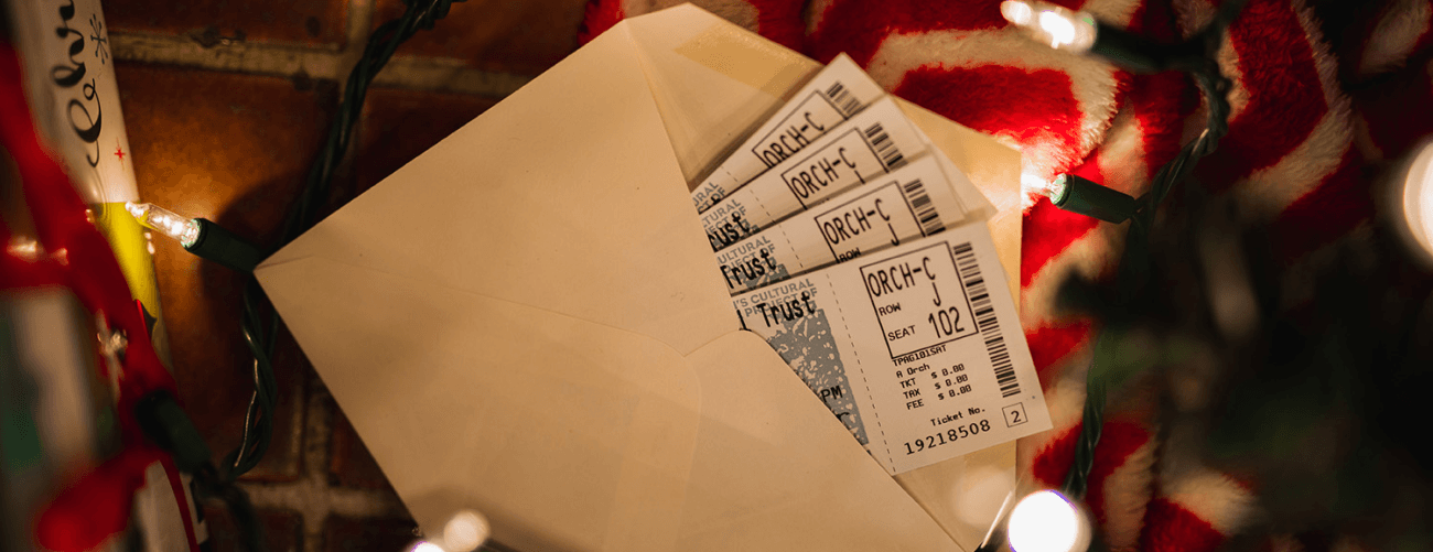 tickets in an envelope, surrounded by holiday decorations